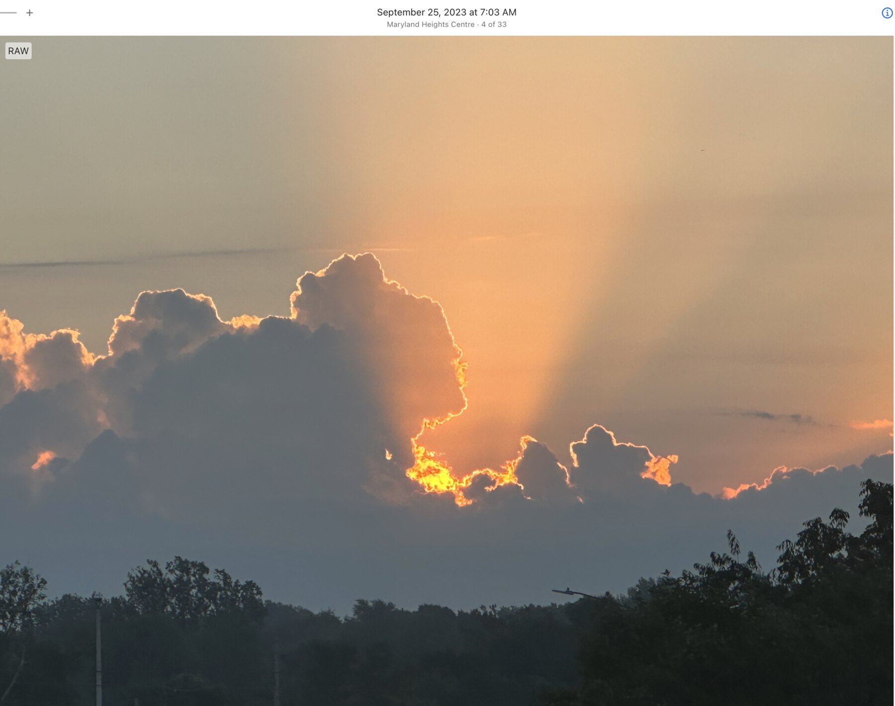Golden light rising behind sculpted clouds in Maryland Heights