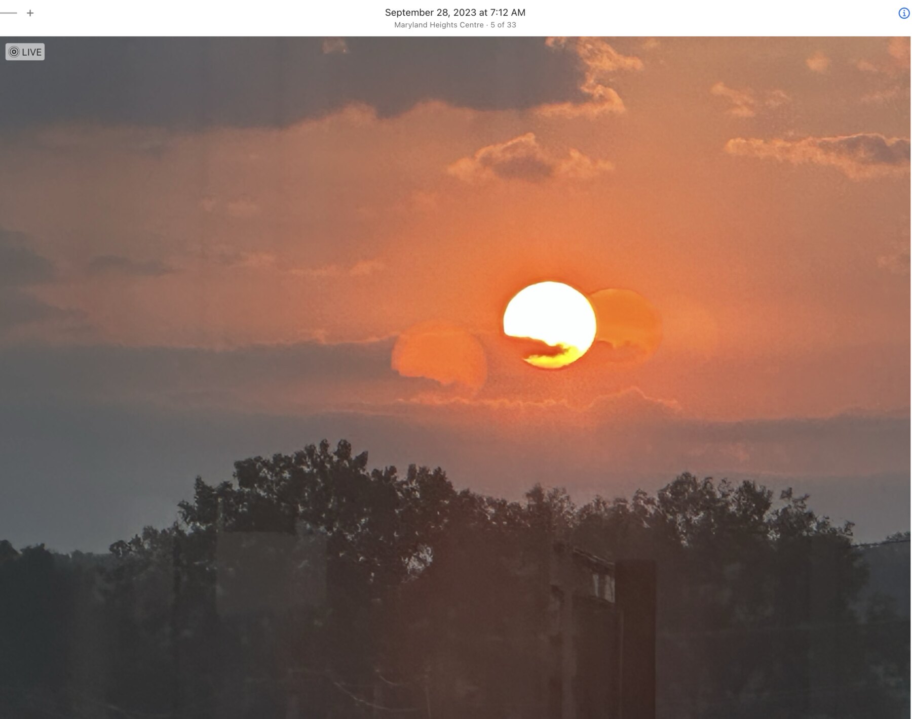 Round sun emerging through an orange cloud bank in Maryland Heights